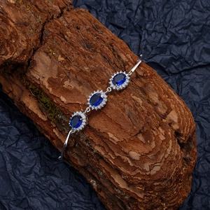 S925 sterling silver bracelet with sapphire blue stones and diamond halo on dark bark