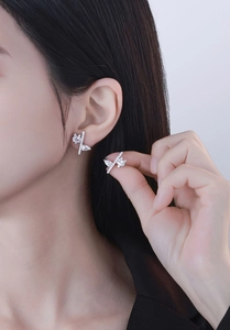 Detail of S925 sterling silver stud earrings with irregular diamond-set crisscross design