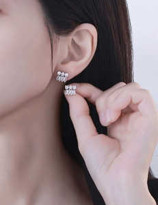 Close-up of S925 silver stud earrings with sparkling cubic zirconia on model's ear