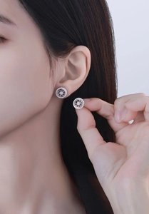 Close-up of S925 sterling silver dreamcatcher stud earrings on model's ear with shiny crystals