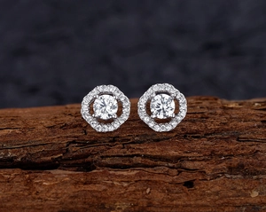 Close-up of octagonal silver stud earrings with a central diamond and micro-pave halo