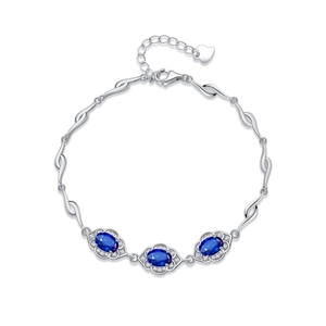 Bracelet en argent 925 avec saphirs bleus ovales et sertissage halo étincelant sur fond blanc