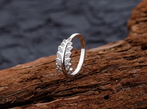 Détail macro d'une bague blé en argent S925 avec zircons sur bloc de bois