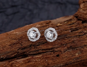 Detailed close-up of diamond-studded S925 silver hexagonal stud earrings on dark wood