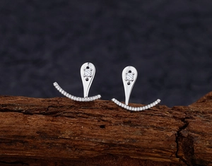 Vue macro de boucles d'oreilles goutte en argent S925 avec zircons sur bois sombre