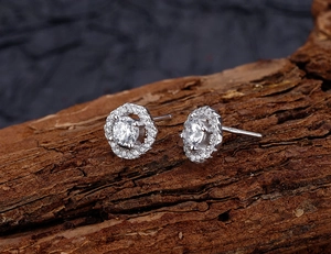 Macro shot of S925 sterling silver diamond earrings on a natural wood texture background