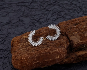 Dettaglio macro di orecchini a girasole in argento con pavé di zirconi scintillanti