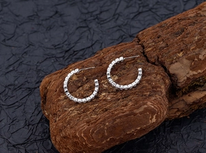 Makroaufnahme von S925 Sterlingsilber C-Ohrringen mit funkelnden Pavé-Zirkonia-Steinen