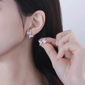 Asymmetric silver S925 stud earrings with sparkling crystals shown on ear for style