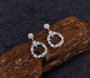 Close-up of silver round drop earrings with sparkling marquise and round cut zircons