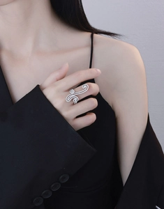 Detail of a large S925 silver swirl ring encrusted with sparkling cubic zirconia pavé