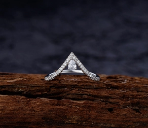Macro view of a V-shaped sterling silver ring with micro-pave diamonds and pear cut stone