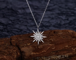 Macro view of S925 silver starburst pendant necklace with pavé set white zircon stones