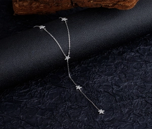 Détail macro des glands étoiles en argent S925 sur un collier au design en Y