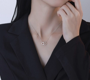 Détail du collier à pendentif double anneau entrelacé en argent S925 sur un mannequin