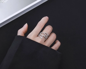 Bague en argent S925 sertie de diamants sur main avec fond sombre au style minimaliste
