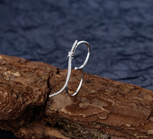 Macro shot of S925 sterling silver double-finger ring with zircons on natural bark