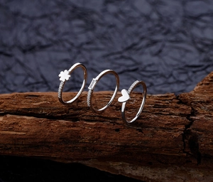 Macro shot of S925 silver rings set with clover, heart, and zircon details