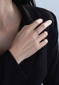 Macro detail of V-shaped S925 sterling silver ring featuring a pear-cut centerpiece stone