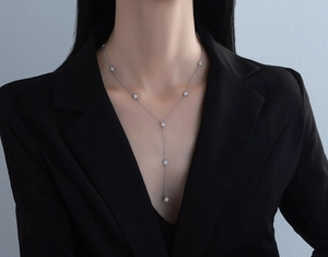 Détail du collier à pampilles étoiles en argent S925 sur mannequin en blazer noir