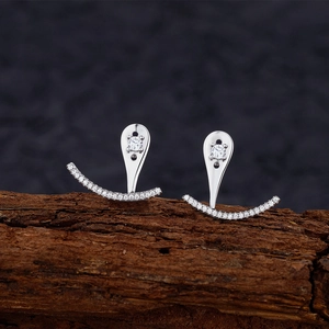 Boucles d'oreilles élégantes en argent S925 avec zircons sur fond de bois sombre