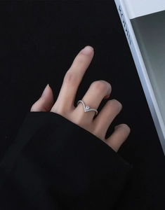 Macro detail of V-shaped S925 silver ring with pear-cut zircon on a model finger