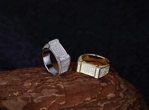 Vue macro de bagues rectangulaires en argent et or pavées de zircons étincelants
