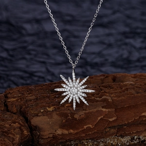 Sparkling starburst pendant necklace in S925 sterling silver for women on rustic wood bark