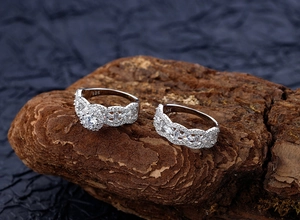 Macro shot of S925 sterling silver rings with micro-paved diamonds on wood surface