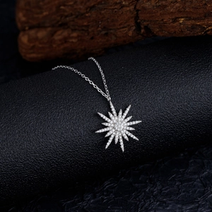 Elegant S925 sterling silver starburst necklace with pavé zircon pendant on a black stand