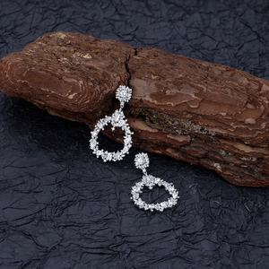 Luxe S925 silver cluster earrings with multi-cut crystals on wood bark display