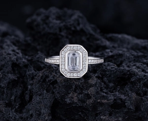 Macro shot of S925 silver ring with rectangular emerald cut center stone on black rock base