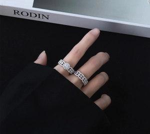 Macro detail of micro-paved silver rings with synthetic diamonds worn on hand