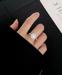 Macro detail of S925 silver emerald cut ring with micro-paved diamonds on hand