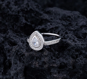 Detailed macro shot of pear-shaped cubic zirconia S925 sterling silver ring on black rock
