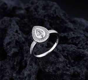 Macro shot of S925 sterling silver teardrop ring with pavé diamonds on volcanic rock