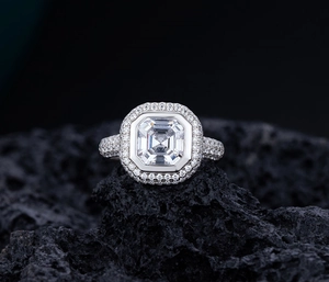 Gros plan d'une bague avec diamant taille émeraude sur pierre volcanique noire