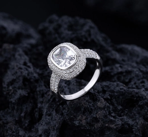 Macro shot of S925 sterling silver square cushion-cut iced out ring on black rock