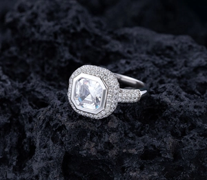 Détail de bague en argent avec pierre de taille émeraude et pavé de diamants sur lave