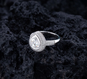 Vue macro d'une bague en argent S925 avec pierre en forme de poire sur roche noire