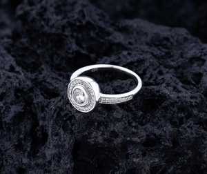 Macro detail of S925 sterling silver ring with micro-pave diamonds on black lava rock