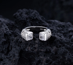 Close-up of S925 silver ring with emerald-cut crystals and 925 hallmark on black stone