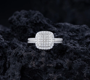Dettaglio ravvicinato di un anello cushion in argento con pavé di diamanti su pietra nera