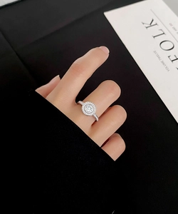 Close-up of S925 sterling silver halo ring with pavé diamonds on a model's hand