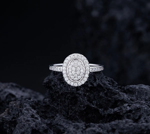 Macro shot of oval full-diamond S925 sterling silver ring on black textured stone