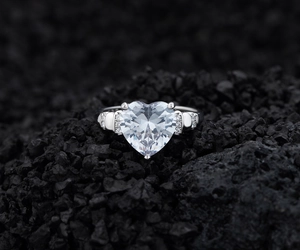Détail macro d'une bague diamant cœur sur roche volcanique avec sertissage à griffes
