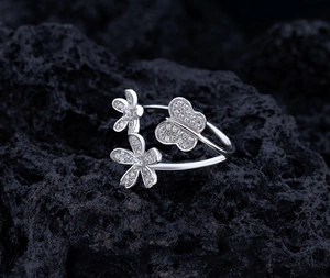 Macro shot of silver ring featuring zirconia-encrusted flower and butterfly patterns