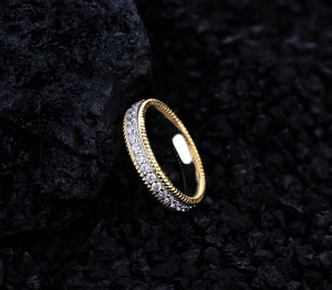 Macro shot of two-tone braided edge eternity ring with round cut cubic zirconia stones