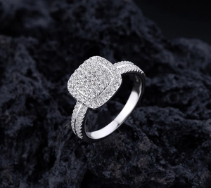 Macro di un anello in argento con grappoli di diamanti su pietra vulcanica scura