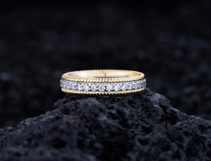 Macro detail of gold twisted edge ring with sparkling white gemstone pavé setting